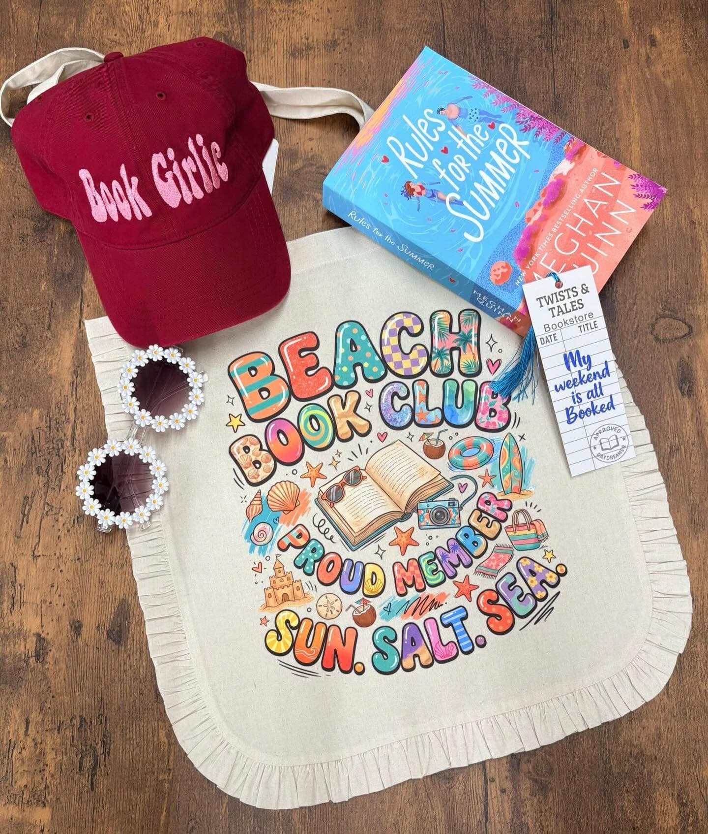A beach-ready book club tote packed with a sun hat, sunglasses and summer reads.