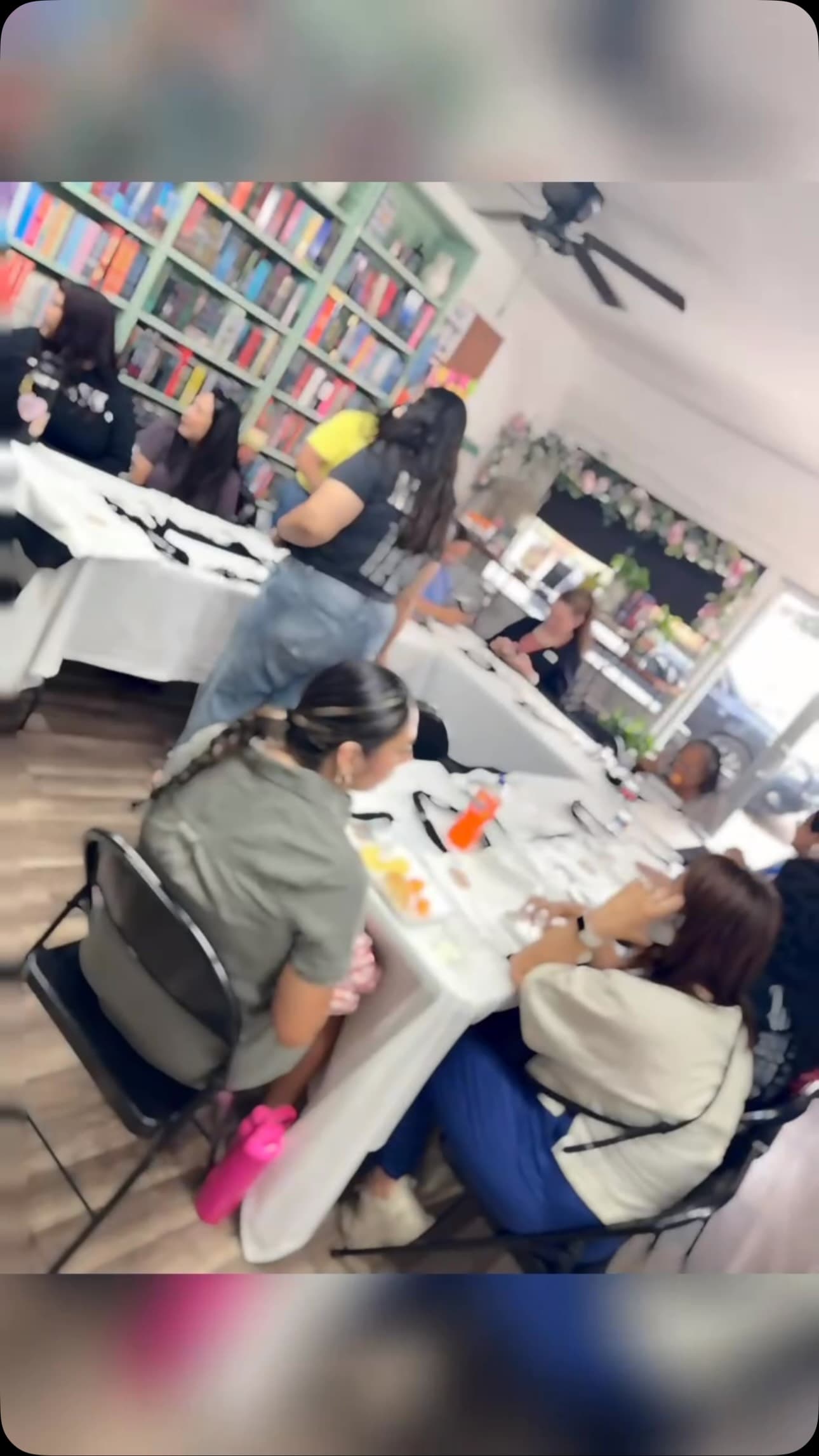 Readers seated around a long table at Twists & Tales building their own bookish tote bags.